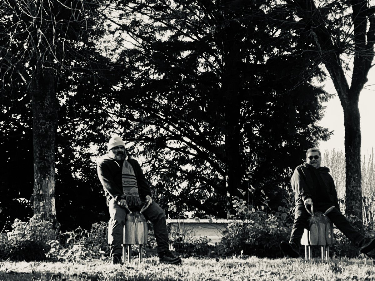 Milos (left) and Rico (right), sitting on spring riders in a garden, black and white photograph
